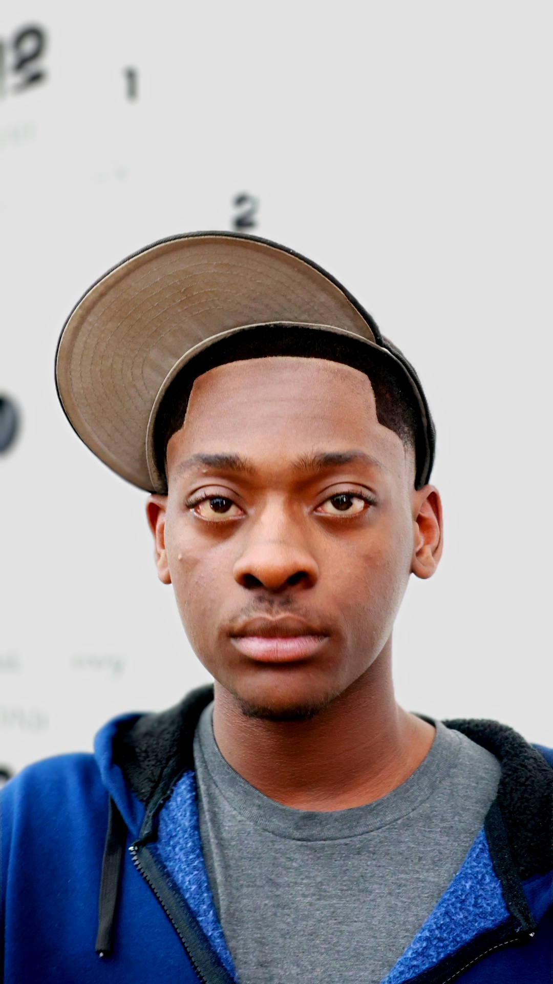 Portrait — front-facing, bucket hat, blue hoodie